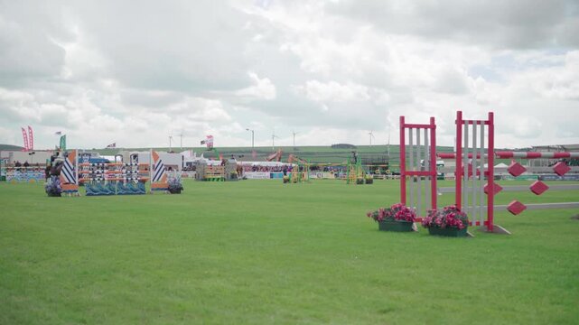 Equestrian rider jumping over obstacle during professional show jumping competition at outdoor arena.
