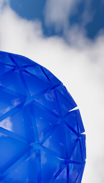 Blue geometric dome with triangular glass panels reflecting sky