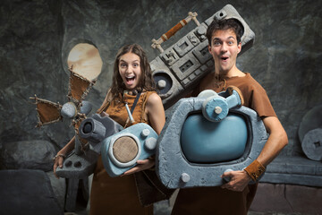 Fototapeta premium Prehistoric Couple Carrying Stone Electronics