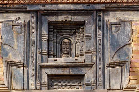 Nepal. Central Nepal. Kathmandu. Kathmandu Valley. Bhaktapur. Durbar Square. A traditional Newar wooden window featuring a divine figure carved in relief at its centre