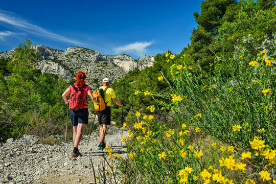 Man and woman hiking on a rocky mountain trail in France