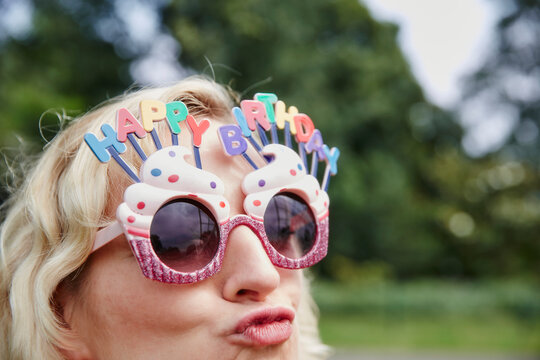 Woman pouting wearing birthday eyeglasses