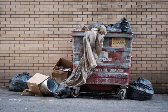 Overflowing Dumpster With Rubbish In Urban Alley
