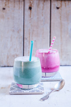 Blue coloured latte with spirulina algae, plant milk, ginger and rice syrup and latte with beetroot juice