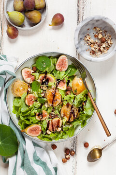 Platter of green salad with figs, Crema di Balsamico, honey hazelnuts and baked goat cheese