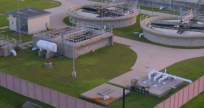 Aerial view of municipal wastewater treatment plant with circular clarifiers and aeration tanks.