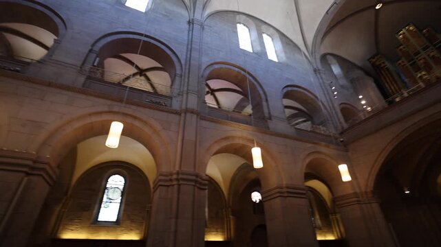 View of Grossmunster interior with stone arches, vaulted ceilings, and pipe organ in the historic church Zurich, Zurich, Switzerland.