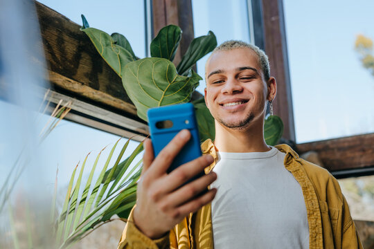 A smiling businessman uses a phone in a coworking space