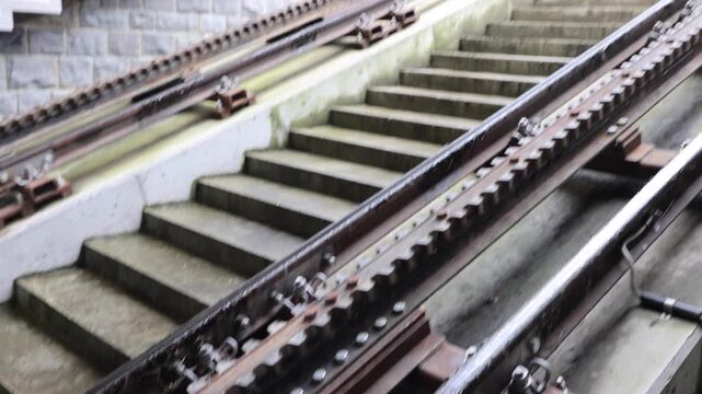 View of the Pilatus Railway cogwheel track and adjacent concrete stairs in Alpnach, Obwalden, Switzerland.