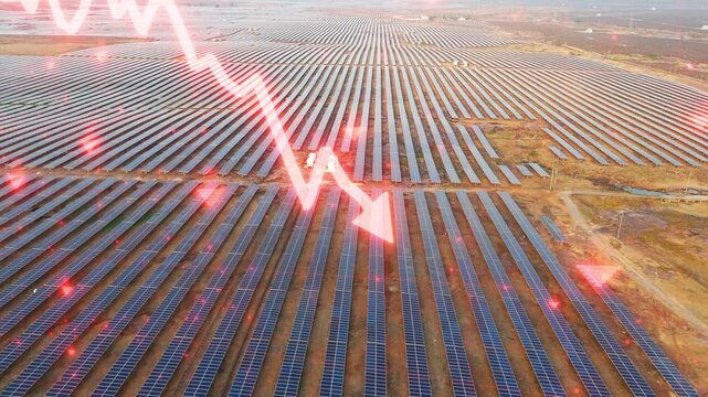 An aerial drone slowly descends and moves backward over a large solar farm with glowing candlestick graphics, illustrating falling solar energy costs, investment markets, renewable power, and finance
