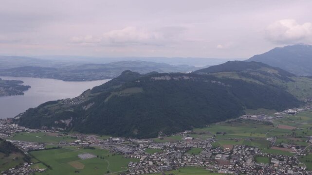 View of the landscape surrounding Stanserhorn-Bahn with Lake Lucerne and the town of Stans nestled among green hills and mountains in Stans, Nidwalden, Switzerland.