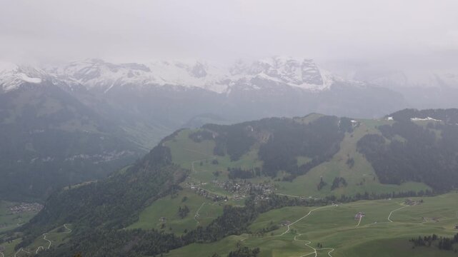 View of the Stanserhorn-Bahn cable car route winding through the lush green mountain slopes and alpine landscape near Stans, Nidwalden, Switzerland.