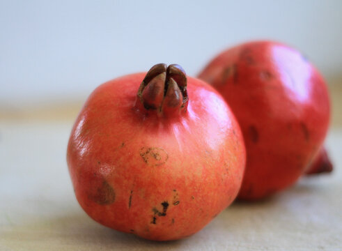 Freshly sliced open organic pomegranate with glossy, ruby-red arils bursting with juice, isolated with generous copy space for healthy food, wellness, and nutrition concepts.
