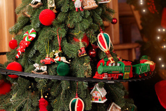 Festive Christmas tree adorned with colorful ornaments and a toy train track