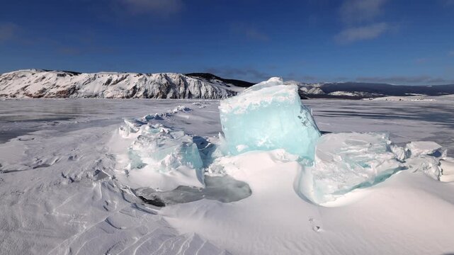 View of large turquoise ice blocks on the frozen surface of Lake Baikal under a clear blue sky in Khuzhir, Irkutsk Oblast, Russia.