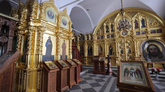 View of the ornate gold-leaf iconostasis with religious icons and intricate woodwork inside the historic Solovetsky Monastery in Solovetsky, Arkhangelsk Oblast, Russia.