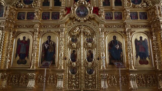 View of the ornate golden iconostasis with religious icons and intricate carvings inside a church at the Solovetsky Islands in Solovetsky, Arkhangelsk Oblast, Russia.