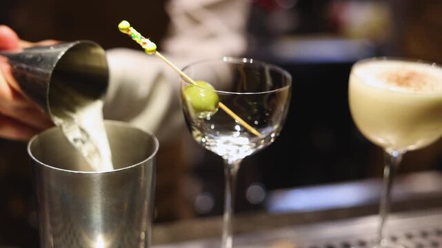 Bartender working, beautiful row line of different coloured liquor alcohol cocktails on a party in a bar, catering banquet on event, barman mixing drinks, selection of beverages in a restaurant club