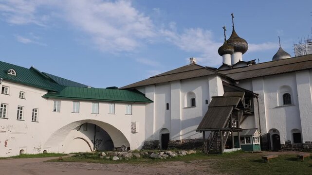 View of the historic white-walled Solovetsky Monastery with its distinctive onion domes, green roofs, and arched stone gateways in Solovetsky, Arkhangelsk Oblast, Russia.