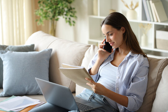 Telecommuter talking on phone checking report