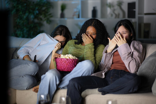 Scared group of friends watching terror movie at home