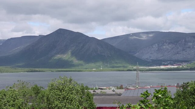 View of the mountains, lake, and industrial landscape near Kirovsk, Murmansk Oblast, Russia.