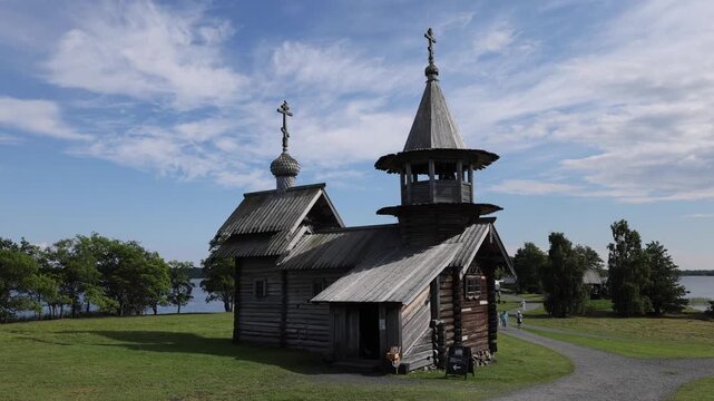View of the historic wooden Kizhi Pogost church with its iconic domes and log architecture set against the scenic Lake Onega in Petrozavodsk, Republic of Karelia, Russia.