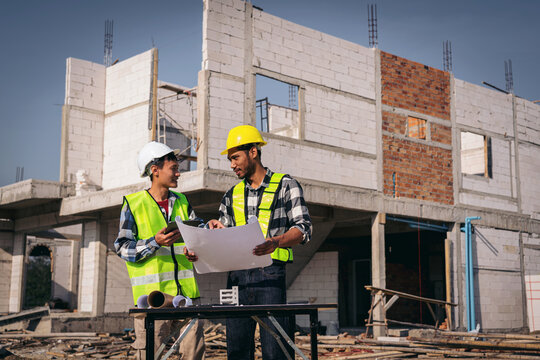 Construction Engineers Discussing Blueprint at Building Site You