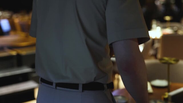 Waiter in uniform serving dishes and drinks on party, server carrying plates with food and beverages at the table, catering service on wedding reception, personnel in cafe restaurant, staff on event
