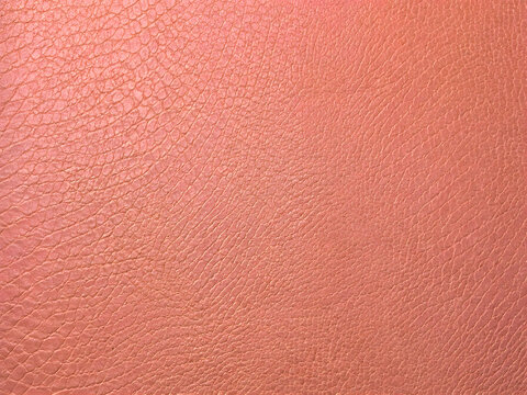 Close-up texture of salmon pink leather with a subtle grain pattern