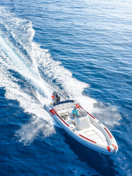 Aerial view of a RIB motorboat with outboard engine cruising with high speed over the ocean