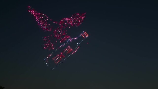 View of a colorful drone show in the night sky forming a bird shape holding a bottle above the city of Seoul, Seoul, South Korea.