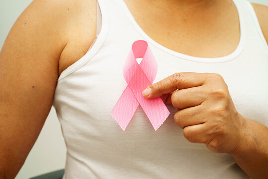 Asian woman with pink ribbon for October world breast cancer day.