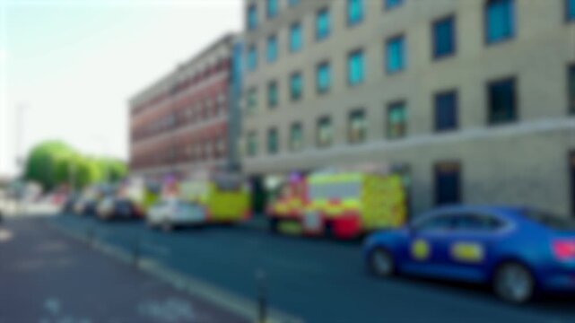 Blurred emergency vehicles and fire engines along busy urban street during incident response. Civilian traffic passing rescue crews. Accidents and disasters public safety concept