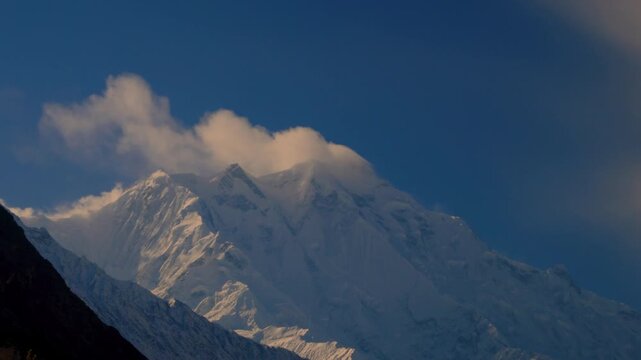 View of the snow-capped Rakaposhi peak under a clear blue sky in the Hunza Valley, Gilgit Baltistan, Pakistan.
