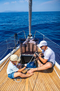 Father and daughter learning yacht maintenance together during a family sailing adventure. Building practical sailing skills, teamwork, confidence and responsibility through shared experience.