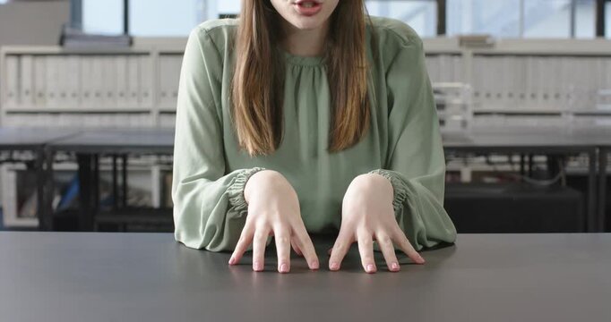 Close up of people talking to the camera, pointing at desk, woman in green blouse sitting in office