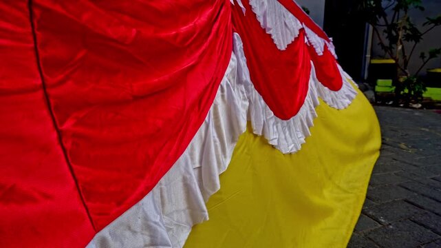 Red, white, and yellow decorative fabric drapes and ruffles creating a festive celebration backdrop for national independence day.
