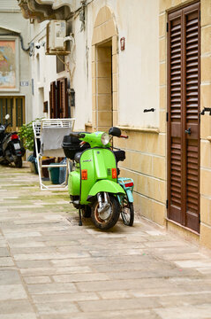 Acid-green Vespa PX scooter parked in front of a house in an old town alley, classic vintage scooter, Gallipoli, Puglia, Salento, Southern Italy 25.11.2025