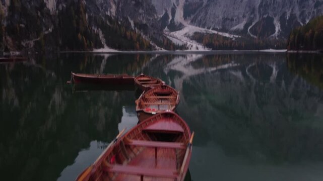 View of wooden rowboats floating on the calm water of Pragser Wildsee in Prags, Trentino-Alto Adige, Italy.