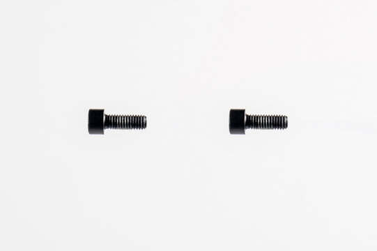 Close-up photo of two black socket head cap screws on an isolated white background