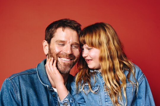 Bonding family time brings a father and daughter close in a warm studio portrait