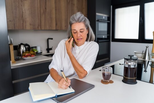 Mature white woman writing in notebook
