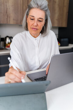 White Woman working with digital pen and laptop at home in Spain