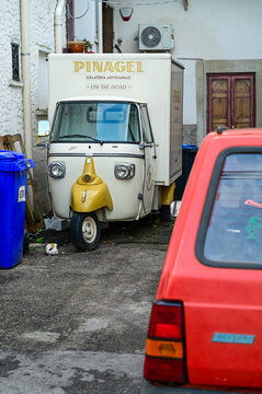 Cream-colored Piaggio Ape Classic gelato sales cart parked behind a red Fiat Panda, "Pinagel" ice cream van, Peschici, Province of Foggia, Gargano, Puglia, Southern Italy 28.11.2025