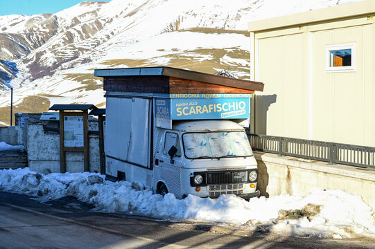 White Fiat 238 food truck from the 1960s/70s for "Panini allo Scarafischio" parked in the snow a classic vintage sales vehicle in Castelluccio di Norcia, Umbria, Italy 30.11.2025