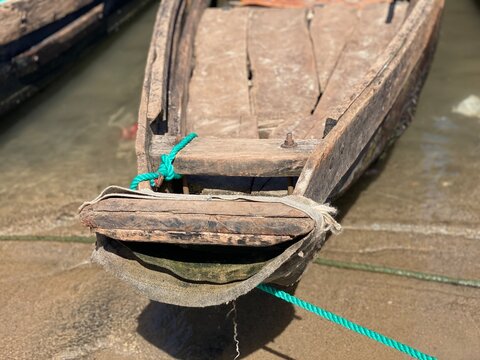 Close Up Front View of Traditional Wooden Boat Bow Tied with Green Rope