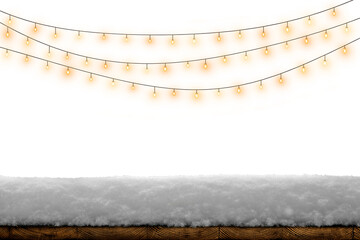 Obraz premium Warm glowing string lights above snow on a rustic wooden board, creating a cozy winter holiday background.
