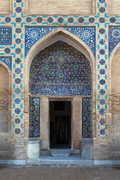 Ornate tiled entrance portal of Gur-e-Amir mausoleum in Samarkand featuring intricate geometric mosaic patterns and Arabic calligraphy. Ideal for travel publications, cultural heritage materials.