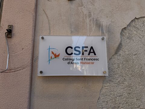 Manacor, spain, august 30, 2026, collegi sant francesc d'assis manacor school sign displaying logo and name on a weathered wall